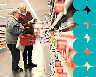 Zwei Personen betrachten Produkte im Supermarktregal.