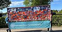 Banner mit bunten Schmetterlingen und Blumen, gehalten von zwei Personen draußen